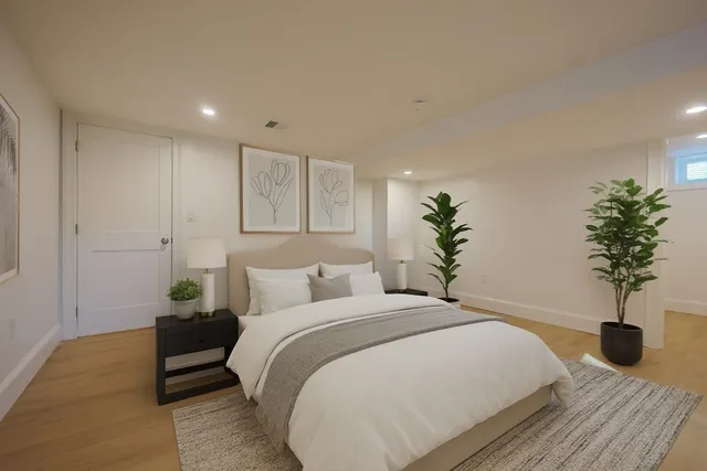 a bedroom with a bed and a potted plant