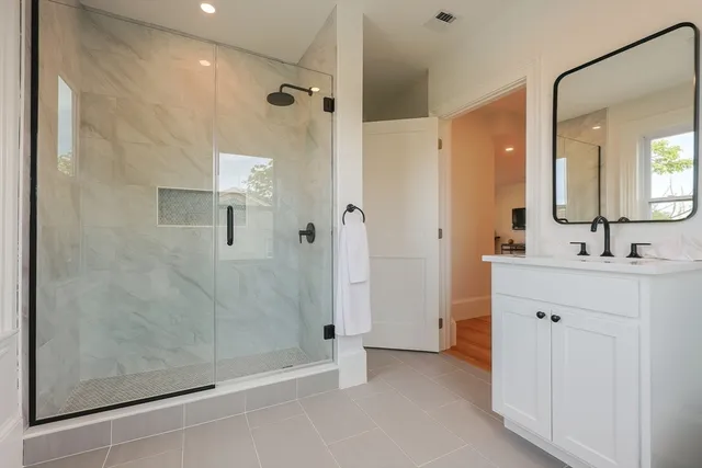 a bathroom with a shower sink and mirror