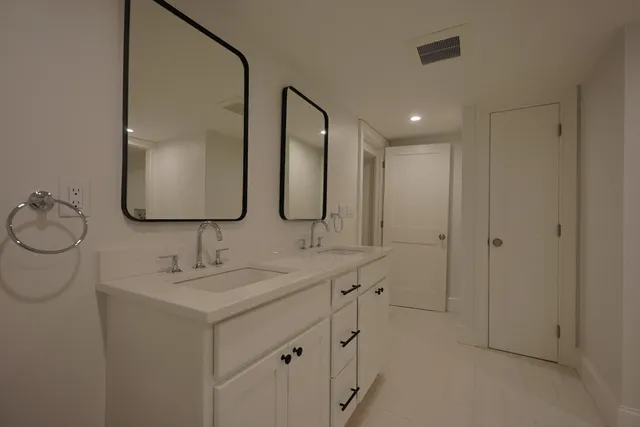 a bathroom with a double vanity sink mirror and