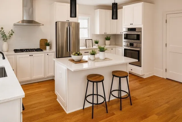 a kitchen with stainless steel appliances kitchen island granite countertop a refrigerator and a stove top oven