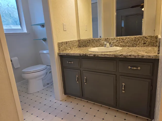 a bathroom with a granite countertop sink and a mirror