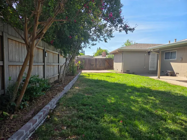 a view of a backyard with wooden fence