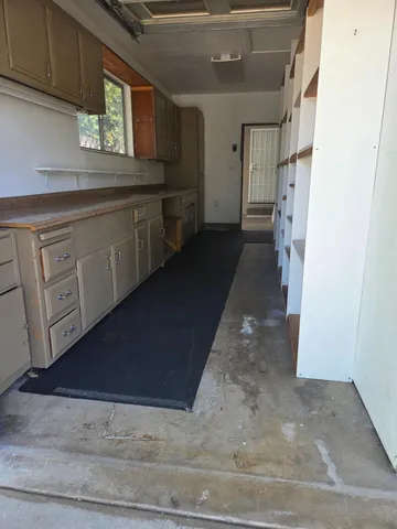 a kitchen with white cabinets and window