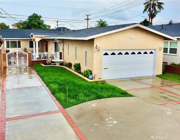 a front view of a house with a garden and table