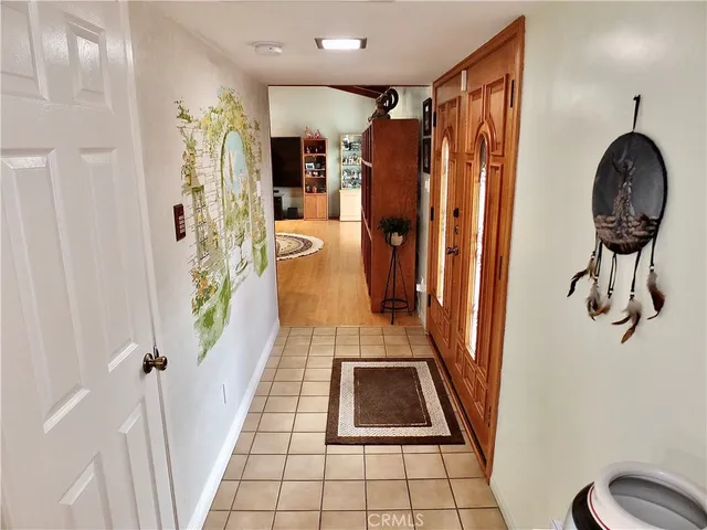 a view of a hallway with wooden floor and a bathroom