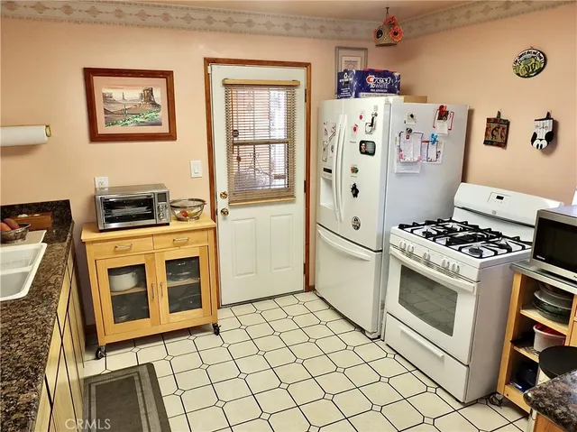 a kitchen with stainless steel appliances granite countertop a refrigerator stove and sink