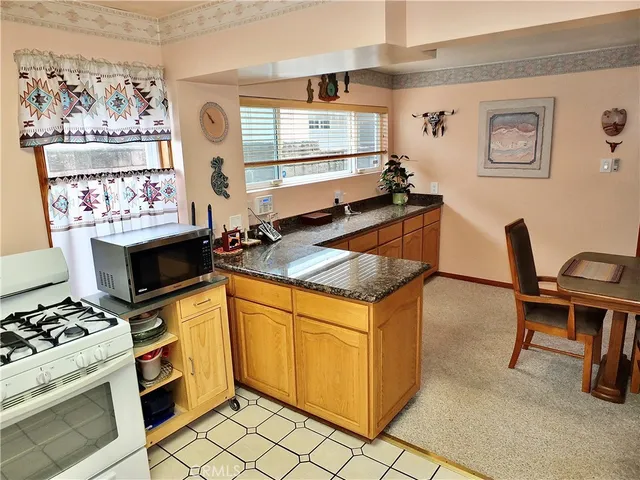 a kitchen with stainless steel appliances granite countertop a stove a sink and a microwave