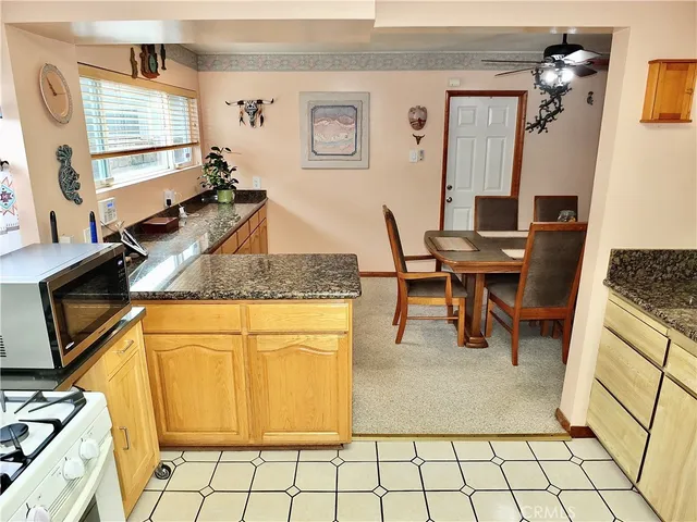 a kitchen with granite countertop a sink a stove and cabinets