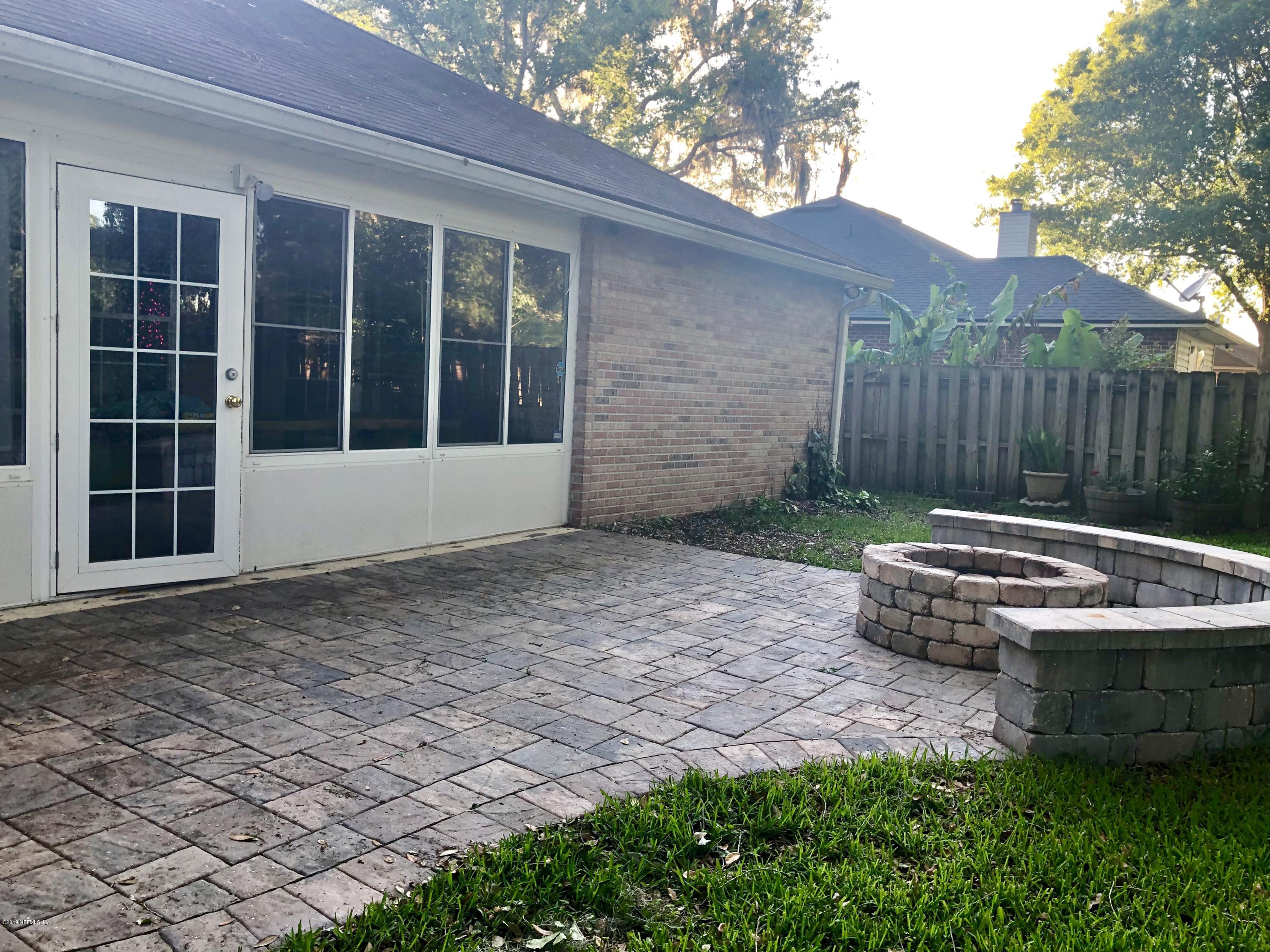 2457 Mallory Hills Road Jacksonville, FL 32221 - Photo 19 of 20 a view of a backyard with table and chairs and wooden fence