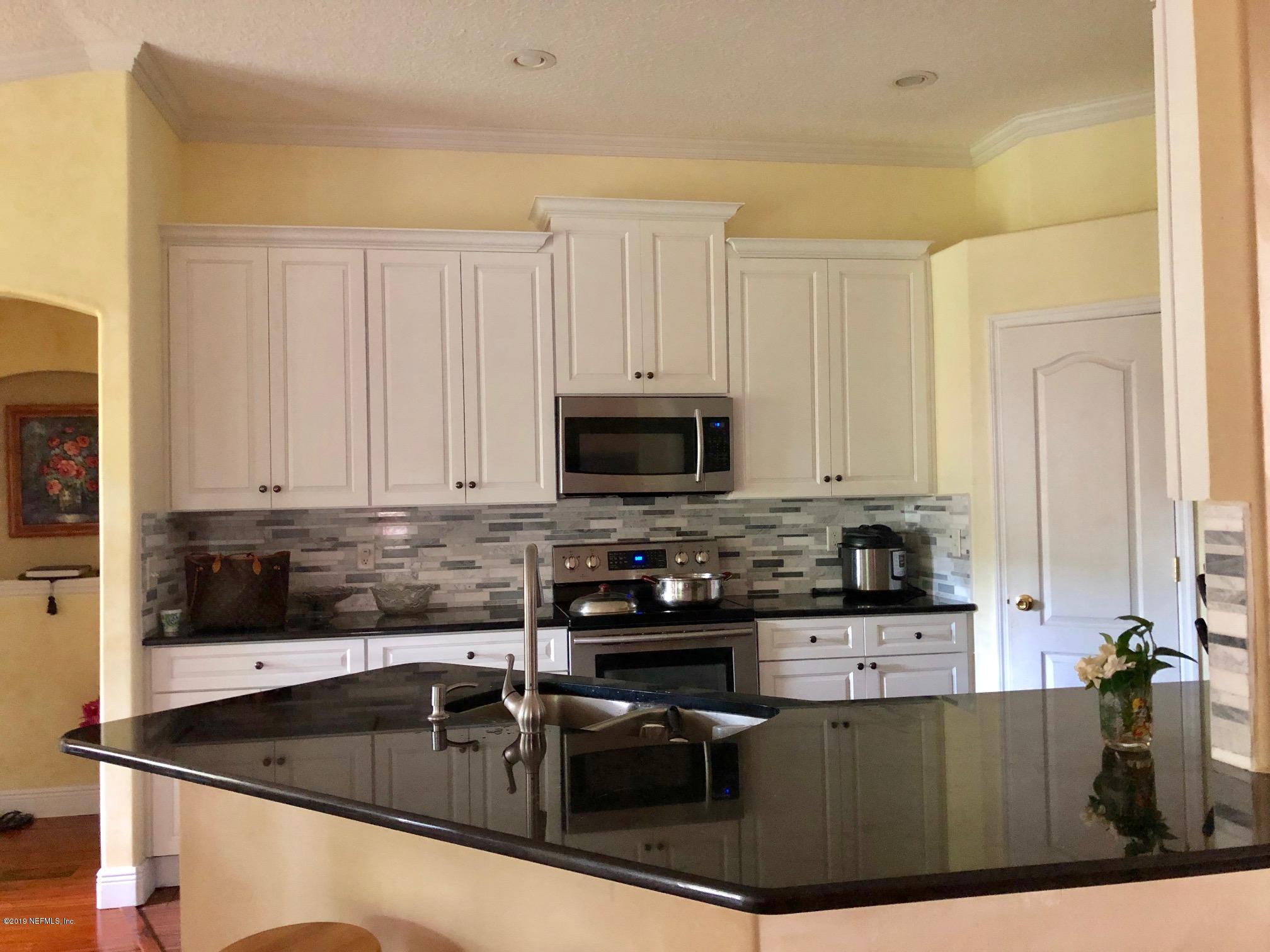 2457 Mallory Hills Road Jacksonville, FL 32221 - Photo 3 of 20 a kitchen with stainless steel appliances granite countertop a stove a sink and a microwave