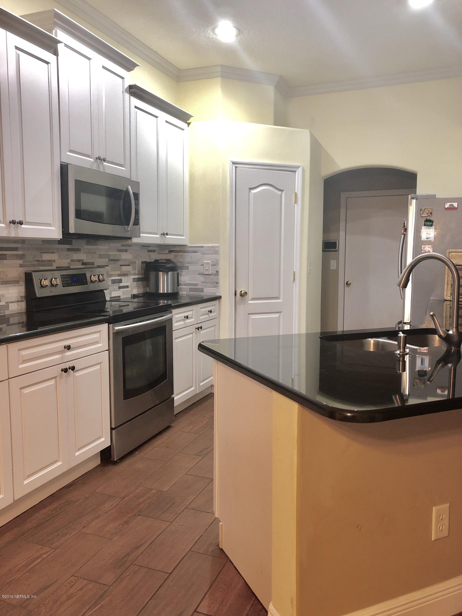 2457 Mallory Hills Road Jacksonville, FL 32221 - Photo 4 of 20 a kitchen with stainless steel appliances granite countertop a sink a stove and microwave