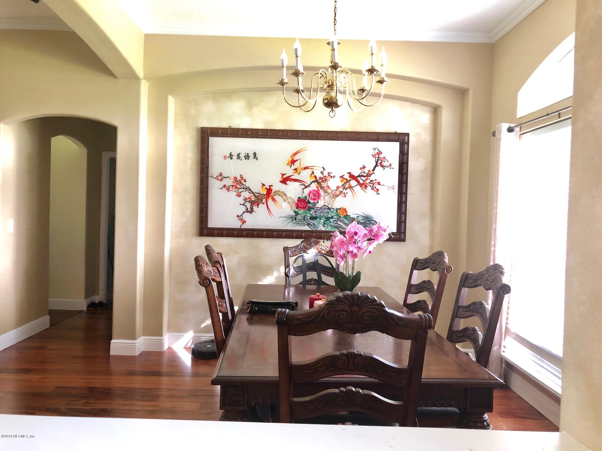 2457 Mallory Hills Road Jacksonville, FL 32221 - Photo 5 of 20 a view of a dining room with furniture wooden floor and a chandelier