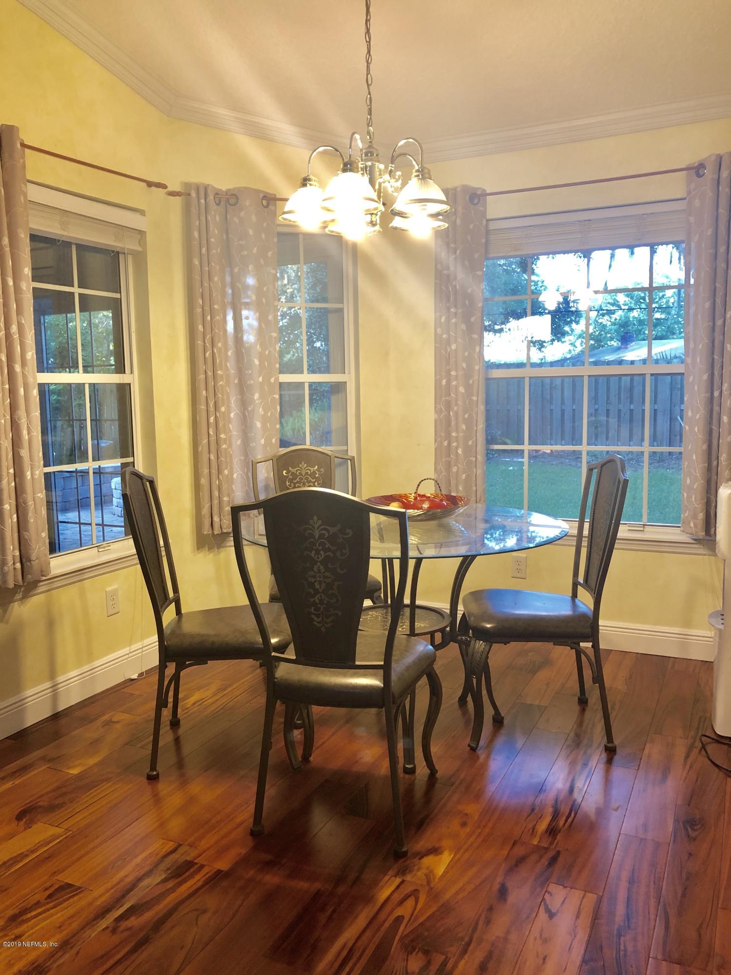 2457 Mallory Hills Road Jacksonville, FL 32221 - Photo 7 of 20 a view of a dining room with furniture wooden floor and a chandelier