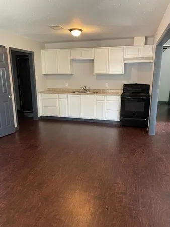 a kitchen with granite countertop a refrigerator and a stove