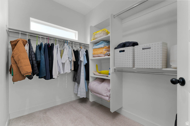 8307 Durham Street Sandy, UT 84070 - Photo 16 of 29 Walk-in closet featuring carpet flooring, built-in shelving, hanging rods, and a high horizontal window
