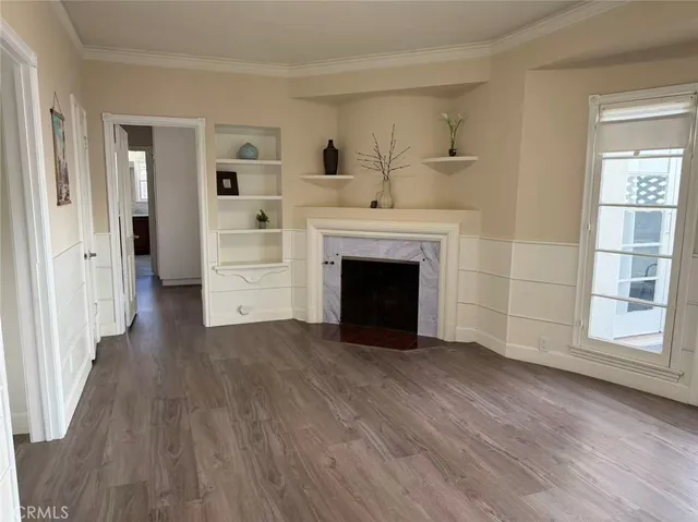 wooden floor fireplace and windows in an empty room