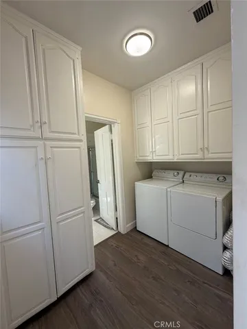 a view of a kitchen with refrigerator and wooden floor