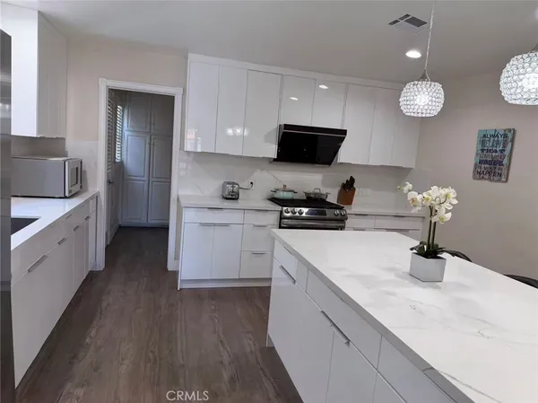 a kitchen with granite countertop a sink stainless steel appliances and cabinets