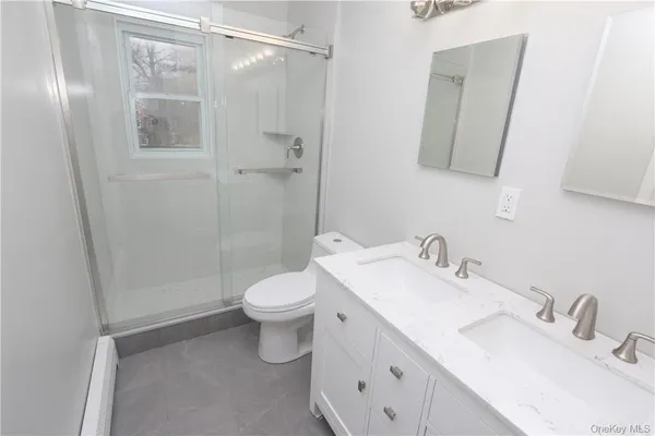 a bathroom with a sink a toilet and shower