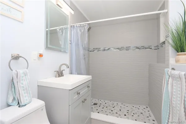 a bathroom with a sink a toilet and shower