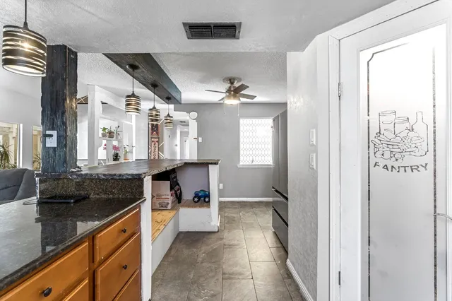 a spacious bathroom with a granite countertop sink a mirror and a bathtub