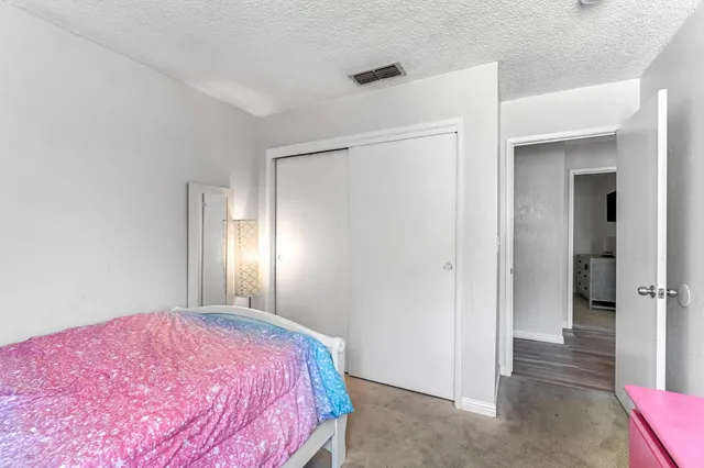 a bedroom with a bed and a chandelier fan