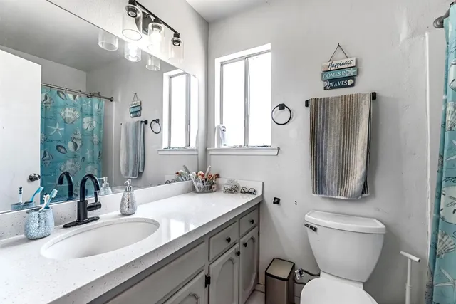 a bathroom with a toilet sink and mirror