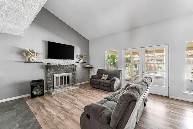 a living room with furniture a fireplace and a flat screen tv