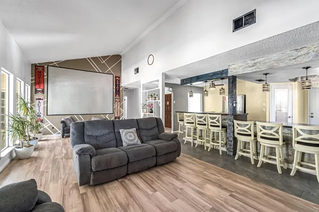 a living room with furniture kitchen view and a large window