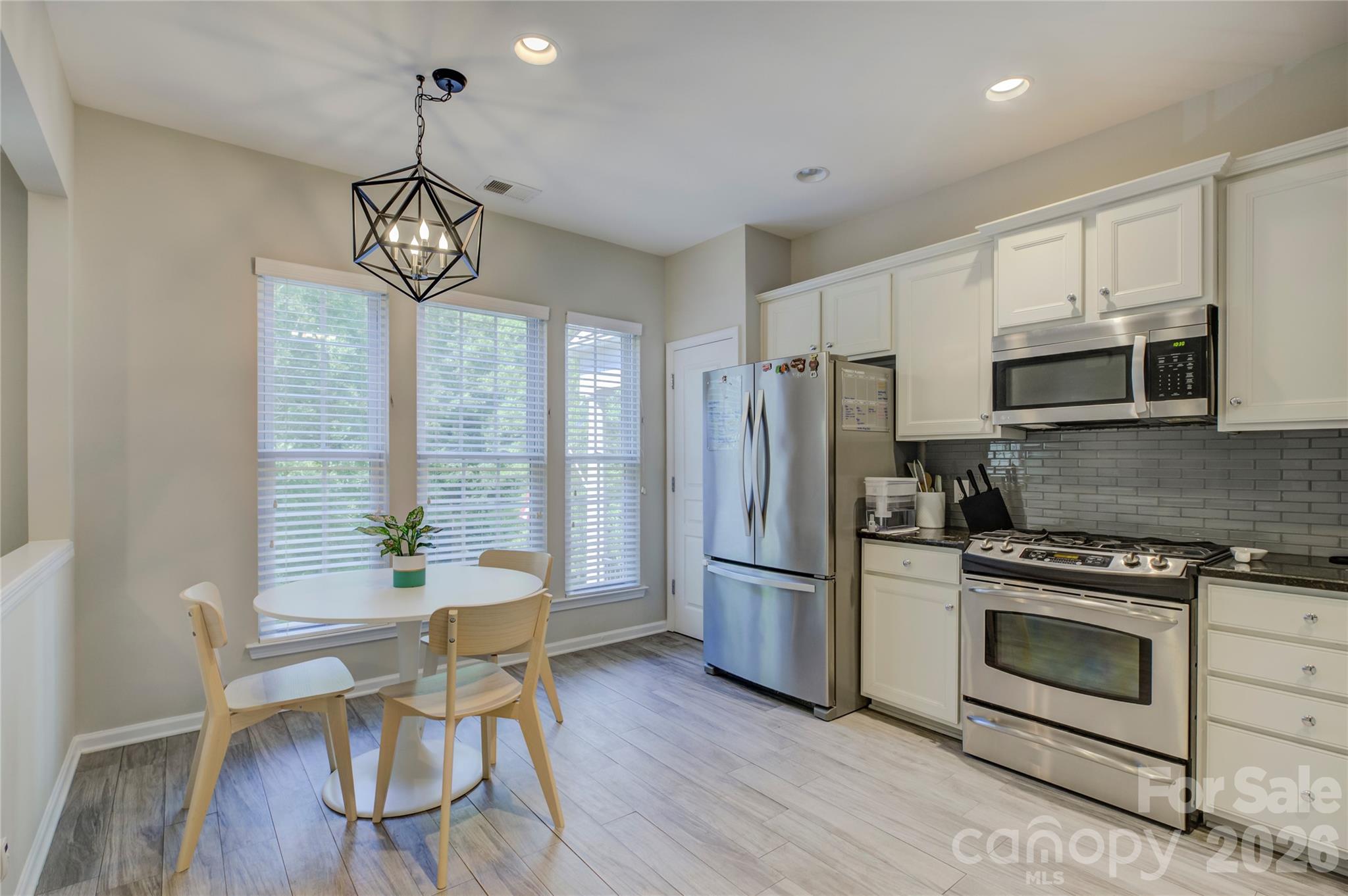 629 6th Baxter Crossing Fort Mill, SC 29708 - Photo 6 of 48 a kitchen with stainless steel appliances a table chairs and chandelier