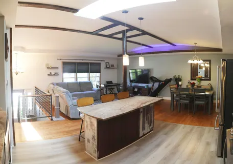 a kitchen with stainless steel appliances kitchen island granite countertop a table and chairs in it