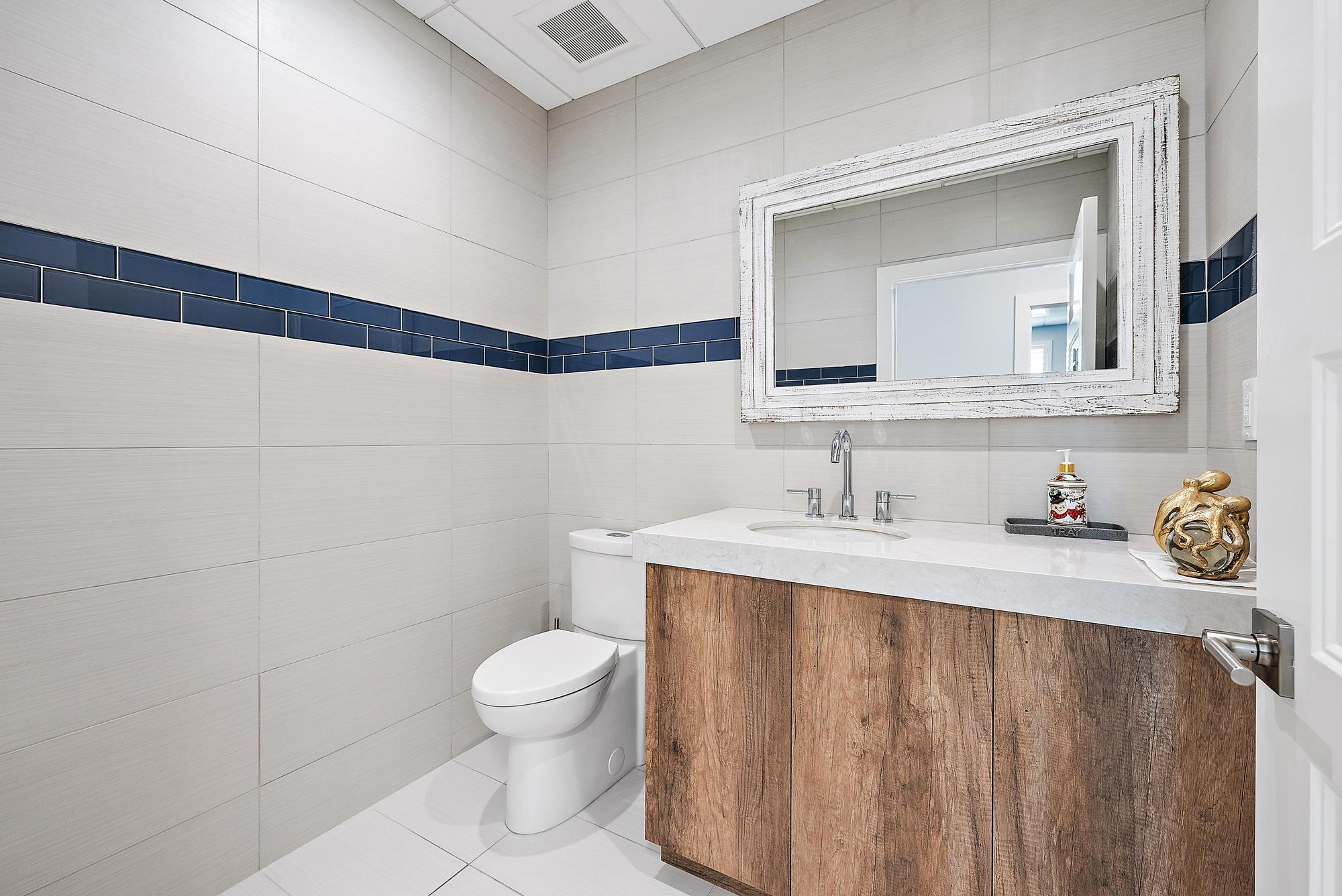 1125 Old Dixie Highway, Unit 4&5 Lake Park, FL 33403 - Photo 14 of 32 a bathroom with a sink a toilet and a mirror