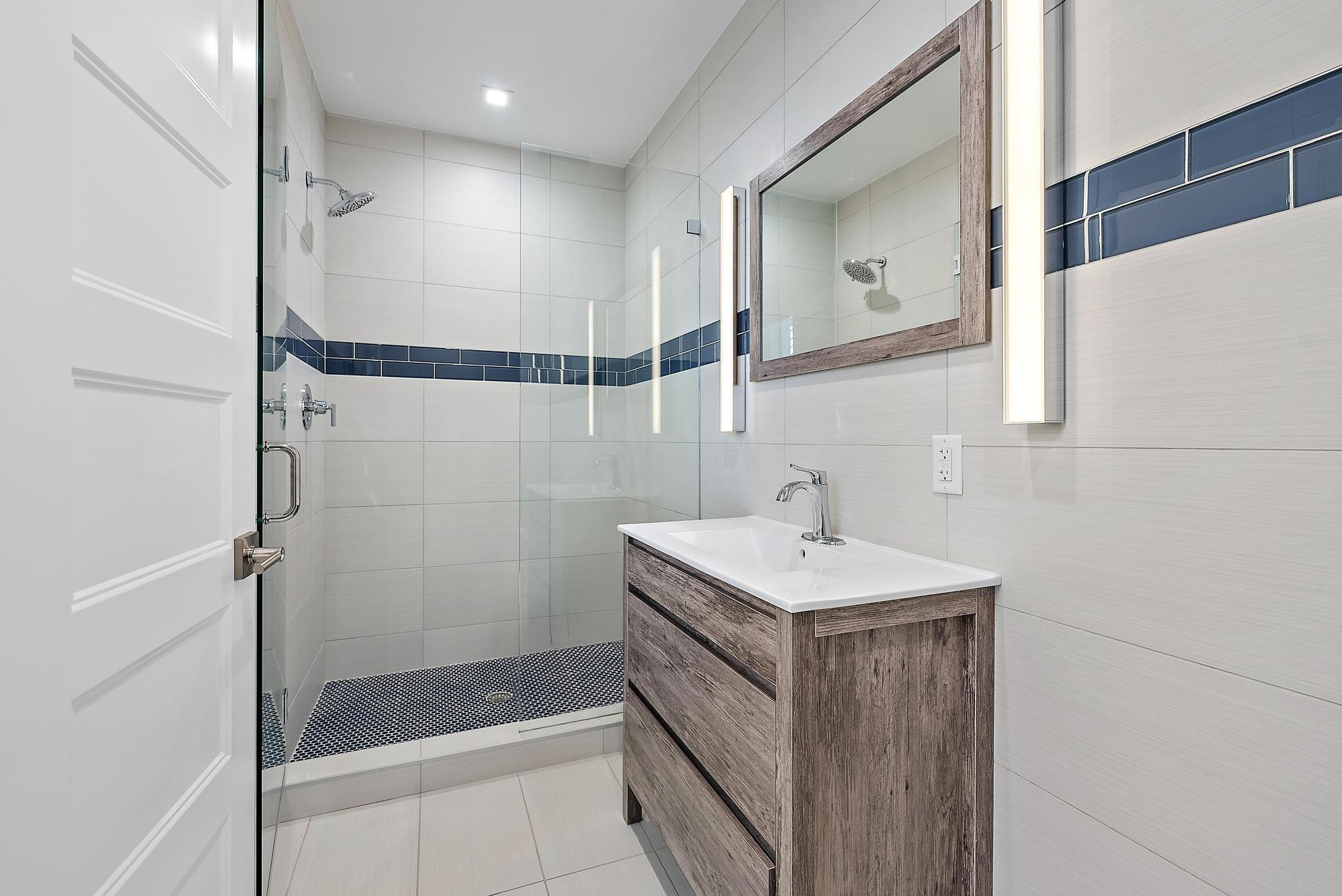 1125 Old Dixie Highway, Unit 4&5 Lake Park, FL 33403 - Photo 17 of 32 a bathroom with a sink a mirror and shower