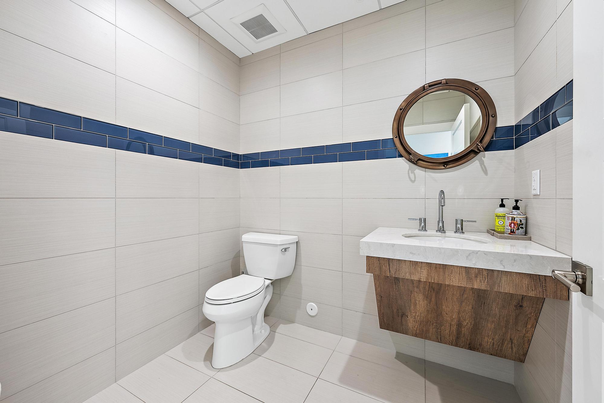 1125 Old Dixie Highway, Unit 4&5 Lake Park, FL 33403 - Photo 19 of 32 a bathroom with a toilet sink vanity and mirror