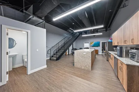 a kitchen with stainless steel appliances granite countertop a stove a sink dishwasher and white cabinets with wooden floor