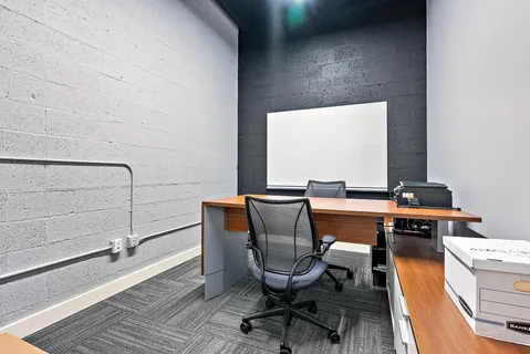 a view of a workspace with furniture and wooden floor