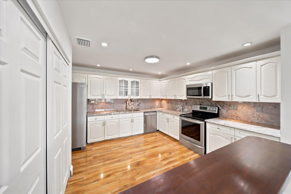 20009 Northwest 66th Place Hialeah, FL 33015 - Photo 13 of 33 a kitchen with stainless steel appliances kitchen island granite countertop a stove and white cabinets