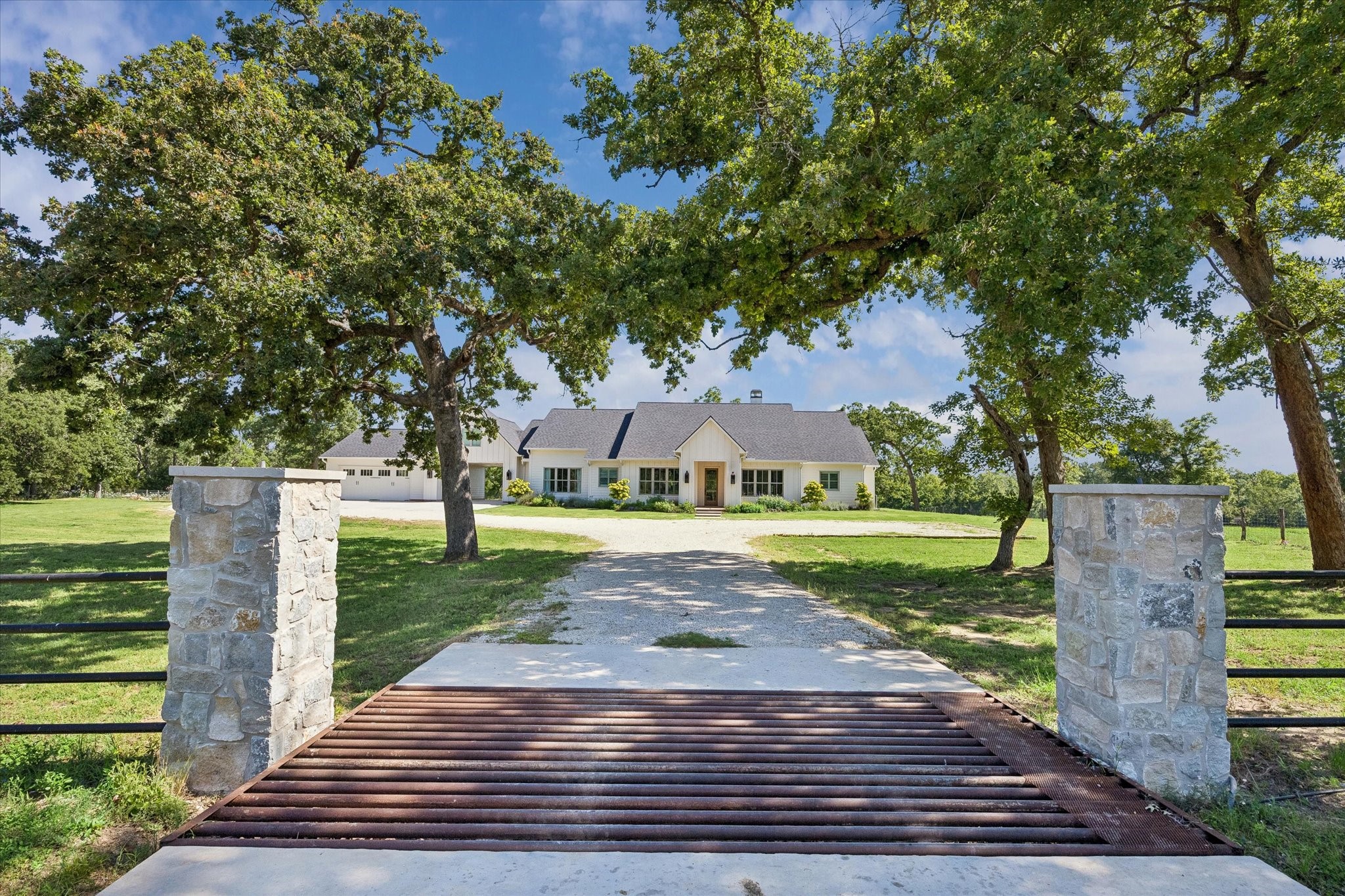 4052 Kuykendall Road Bellville, TX 77418 - Photo 38 of 40 A stone gateway and mature trees frame the driveway, leading to the inviting entrance and a detached garage.