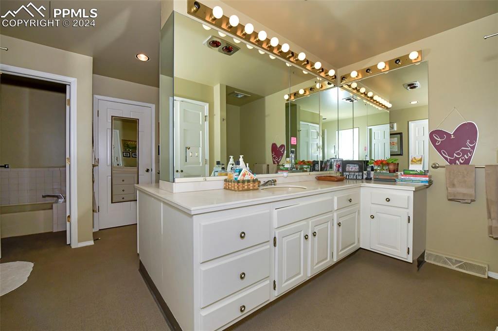 3130 Camels Ridge Lane Colorado Springs, CO 80904 - Photo 15 of 35 a spacious en suite bathroom with a double vanity sink mirror and a bathtub