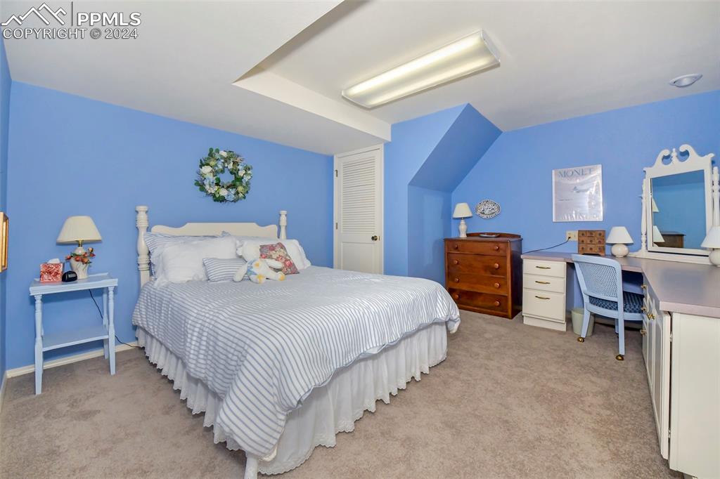 3130 Camels Ridge Lane Colorado Springs, CO 80904 - Photo 18 of 35 a bedroom with bed and a chandelier