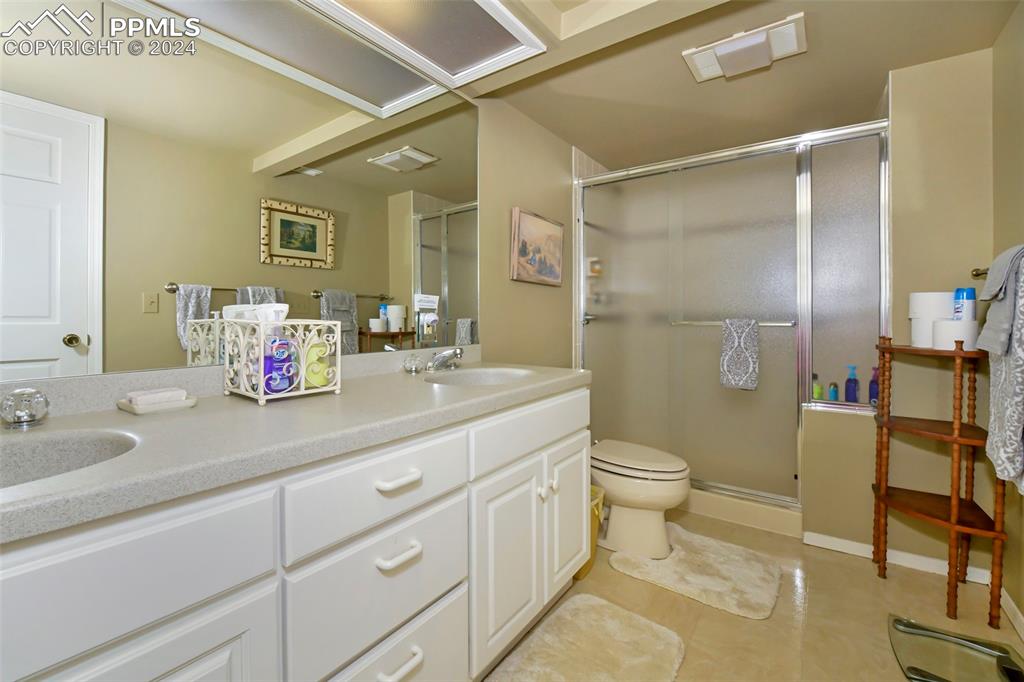 3130 Camels Ridge Lane Colorado Springs, CO 80904 - Photo 25 of 35 a bathroom with a double vanity sink mirror and toilet
