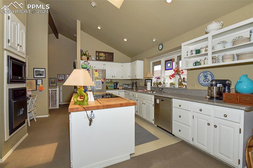 3130 Camels Ridge Lane Colorado Springs, CO 80904 - Photo 7 of 35 a kitchen with stainless steel appliances kitchen island granite countertop a sink a stove and cabinets