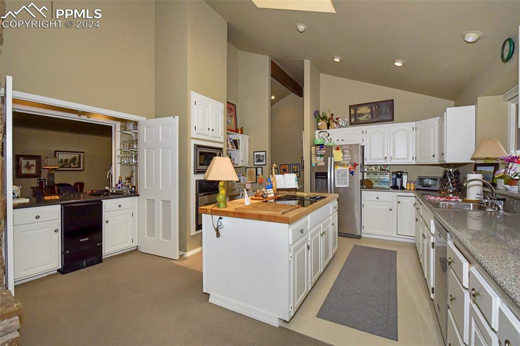3130 Camels Ridge Lane Colorado Springs, CO 80904 - Photo 8 of 35 a kitchen with stainless steel appliances granite countertop a stove top oven a sink a refrigerator and white cabinets