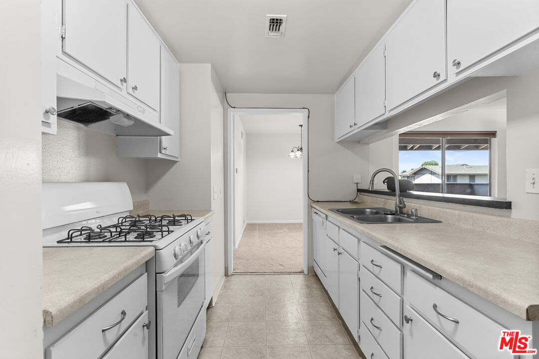 186 Southampton Way, Unit 29 Placentia, CA 92870 - Photo 5 of 20 a kitchen with granite countertop a sink stove and cabinets