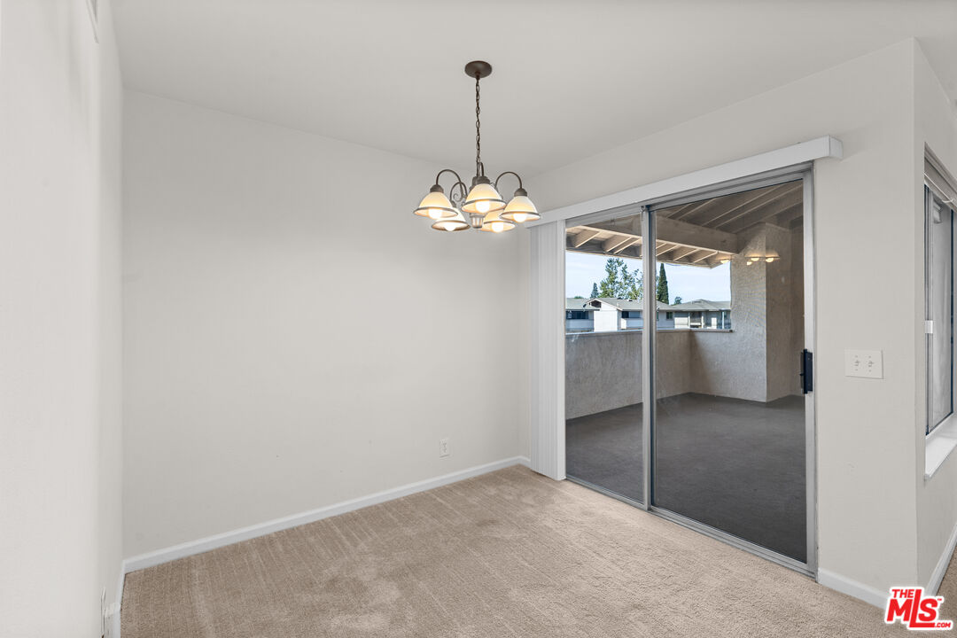 186 Southampton Way, Unit 29 Placentia, CA 92870 - Photo 6 of 20 an empty room and chandelier fan and kitchen view