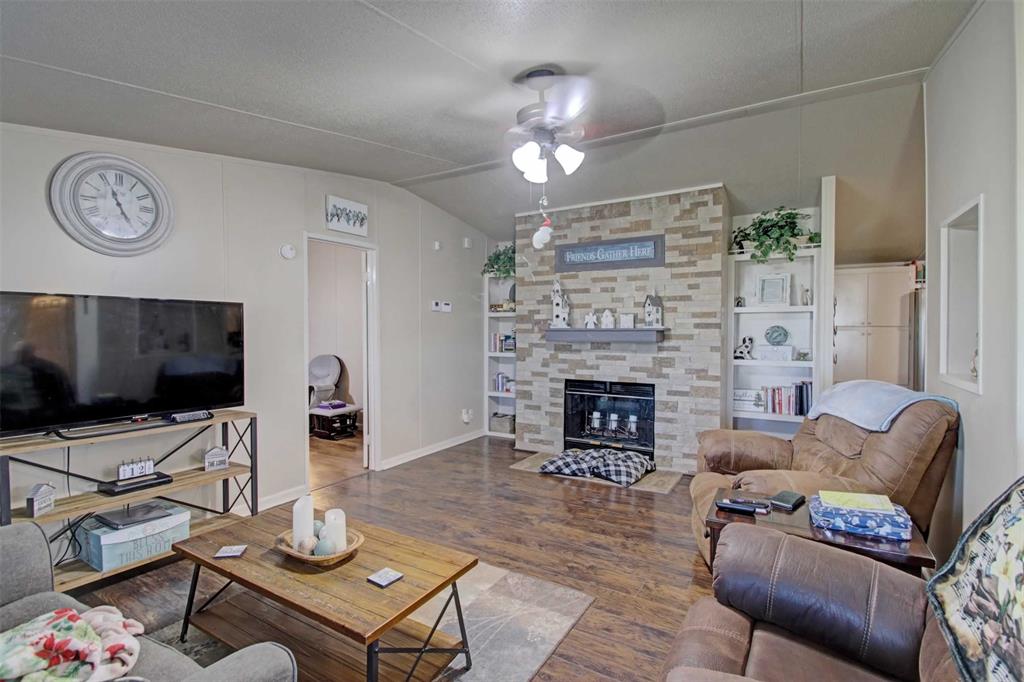 2004 Fall Creek Road Cleburne, TX 76033 - Photo 3 of 18 a living room with furniture a flat screen tv and a fireplace