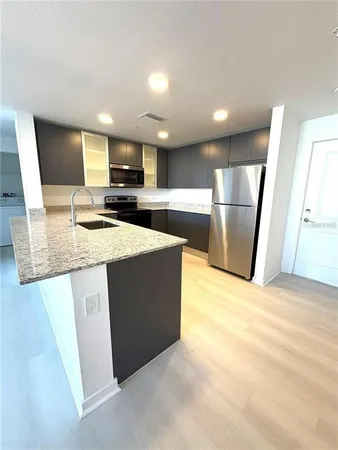 a kitchen with stainless steel appliances granite countertop a sink refrigerator and microwave
