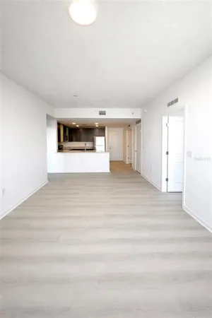 a view of empty room with wooden floor