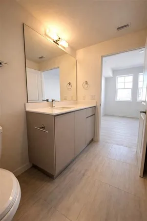 a spacious bathroom with a granite countertop sink and a mirror