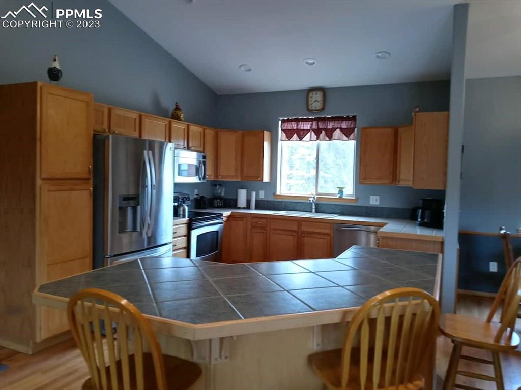 238 Aspen Circle Divide, CO 80814 - Photo 22 of 42 a kitchen with stainless steel appliances granite countertop a refrigerator a sink a stove a dining table and chairs